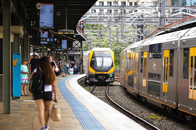 Sydney, Australia - January 20, 2019: Sydney Central train station, two trains getting in and out at the train station with passengers waiting for the train