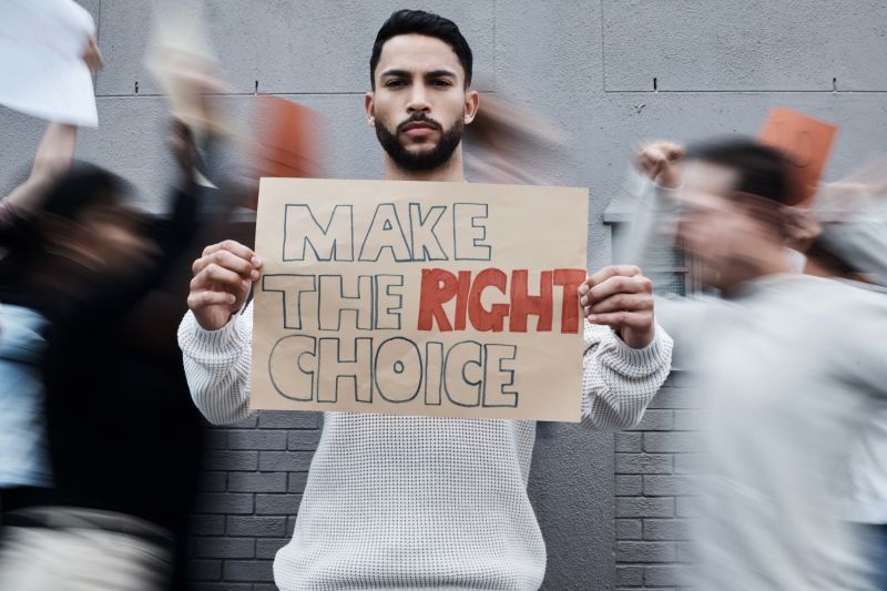 Protestor holding sign saying 'Make the right choice'